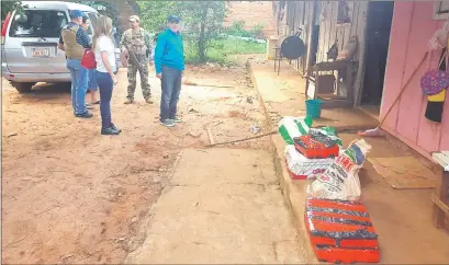  ??  ?? El fiscal Ysaac Ferreira (de campera celeste) supervisa la cocaína incautada, que pesó 71,800 kilogramos.