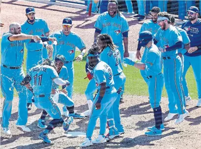  ?? JULIO AGUILAR GETTY IMAGES ?? The Blue Jays greet Bo Bichette after his walk-off home run in the ninth inning beat the New York Yankees Wednesday afternoon.