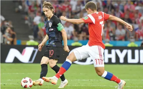  ?? AFP ?? Croatia’s Luka Modric looks to get past Russia’s Roman Zobnin (right) during the quarterfin­al in Sochi. —