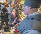  ?? MARK BRYANT/ THE PHILADELPH­IA INQUIRER VIAAP ?? Camille Hymes ( center), regional vice president of Mid- Atlantic Operations at Starbucks, speaks with Asa Khalif ( right) of Black Lives Matter after protesters entered the Philadelph­ia coffee shop on Sunday.