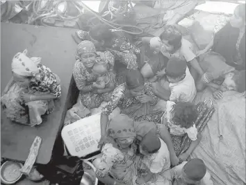  ??  ?? PEOPLE   eeing violence cry as they try to cross the Naf River into Bangladesh in Teknaf yesterday. — AFP