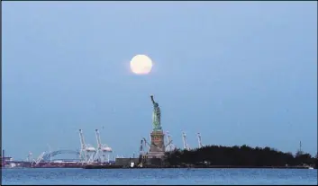  ?? JULIO CORTEZ/THE ASSOCIATED PRESS ?? This June 23, 2013 file photo shows a supermoon over the Statue of Liberty in New York. Monday will have the closest full moon of the year, or every 14 months to be precise. It will also be the closest the moon comes to us in almost 69 years.