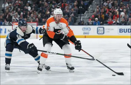  ?? JAY LAPRETE — THE ASSOCIATED PRESS ?? Philadelph­ia Flyers’ Kevin Hayes, right, carries the puck across the blue line as Columbus Blue Jackets’ Eric Robinson defends during the third period of an NHL hockey game Thursday night.