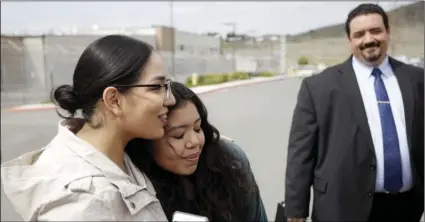  ?? AP PHOTO/GREGORY BULL ?? Chantal Estrada (center) a daughter of Perla Morales Luna, hugs family friend Judith Castro, left, as attorney Andres Moreno looks on (right) in front of the Otay Mesa Detention Center on Tuesday, in San Diego. Morales Luna, a Mexican woman whose...