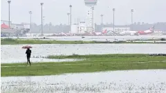  ?? REUTERS ?? A man walks on a field inside Cochin internatio­nal airport after floods submerged the commercial airport in Kochi, India.