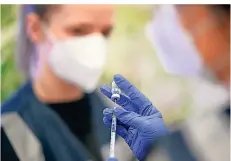  ?? FOTO: FELIX KÄSTLE/DPA ?? Eine Medizinstu­dent vom Zentralen Impfzentru­m in Tübingen zieht eine Spritze mit dem Impfstoff von Pfizer-BioNTech auf.