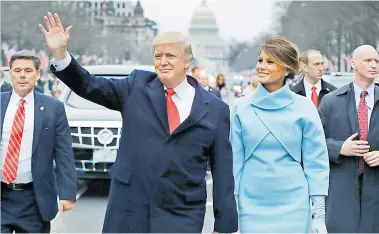  ?? FOTOS EFE ?? Donald Trump y su esposa Melania, rumbo a la Casa Blanca tras jurar el cargo en el Capitolio (al fondo).