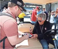  ?? BRIAN SPURLOCK, USA TODAY SPORTS ?? “She said, ‘You son of a gun! You went home and ate?’ ” says Mario Andretti, signing an autograph.