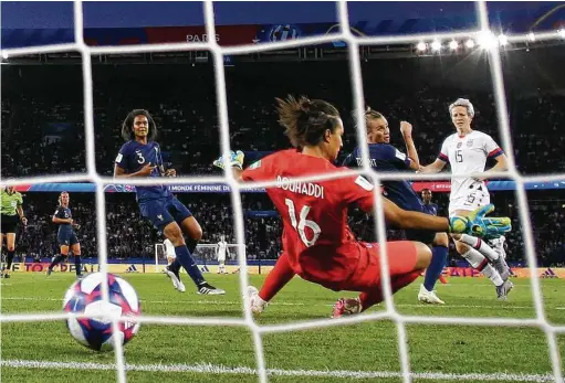  ?? Richard Heathcote / Getty Images ?? U.S. forward Megan Rapinoe, right, beats French goalkeeper Sarah Bouhaddi on an assist from forward Tobin Heath in the second half.