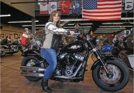  ?? Ivan Moreno / Associated Press ?? Terri Meehan tries out a 2018 Harley Softail Slim at Milwaukee’s House of Harley. According to the Motorcycle Industry Council, women make up 14 percent of the motorcycle riding population. Harley-Davidson is trying to appeal to younger riders.