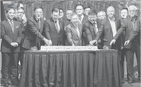  ?? — Gambar Chimon Upon ?? RAIKAN BERSAMA: Dr Sim (tengah) bersama yang lain memotong kek pada Malam Tahun Baharu Cina dan Sambutan Ulang Tahun Ke-50 Hubungan Diplomatik Malaysia-China, malam kelmarin.