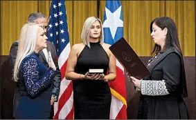  ?? The New York Times/ERIKA P. RODRIGUEZ ?? Wanda Vazquez (left), with her husband and daughter by her side, is sworn in Wednesday by Puerto Rico Chief Justice Maite Oronoz Rodriguez (right) in San Juan.