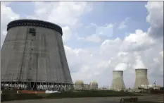  ?? AP PHOTO ?? In this June 13, 2014, file photo, a new cooling tower for a nuclear power plant reactor that's under constructi­on stands near the two operating reactors at Plant Vogtle power plant in Waynesboro, Ga., operated by Westinghou­se Electric Co., the U.S....