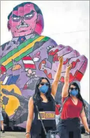  ?? AFP ?? Demonstrat­ors in Brasilia raise clenched fists during a protest seeking the impeachmen­t of Brazilian President Jair Bolsonaro for his handling of the Covid-19 pandemic.