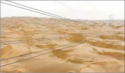  ??  ?? With 1,542 power towers, State Grid’s 563-kilometer transmissi­on line cuts through the Taklimakan Desert, making it the world’s longest 220,000-volt transmissi­on line.