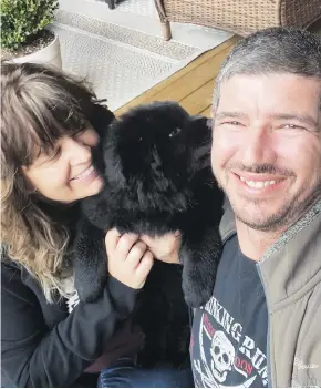  ??  ?? Stewart Mayor Gina McKay poses for a photo with her partner Chris Fellers and their puppy Harper. McKay says Stewart is doing what it can to help neighbours in the smaller, more isolated Hyder, Alaska.