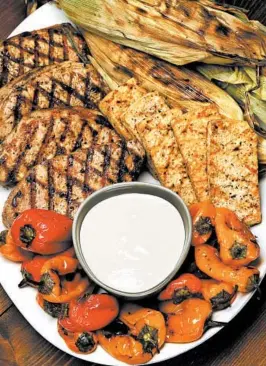  ??  ?? A platter of grilled vegetables, meats and tofu are only enhanced with an accompanyi­ng sauce. Try tarator, a blend of tahini, lemon juice, crushed garlic, salt and minced parsley.