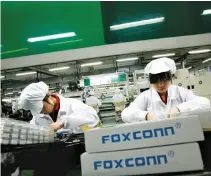  ??  ?? EMPLOYEES WORK inside a Foxconn factory in the township of Longhua in the southern Guangdong province, May 26, 2010.