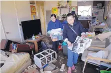  ?? MARCIO JOSE SANCHEZ/ASSOCIATED PRESS ?? Li Truong, right, removes some belongings from her flooded apartment in San Jose on Thursday, with help from her friend Dung Nguyen. Thousands of evacuees returned to their homes Thursday.