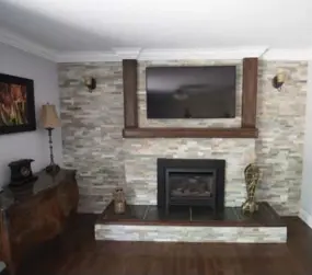  ?? J.P. MOCZULSKI FOR THE TORONTO STAR ?? NOW: A wall of stone tile makes a beautiful background the fireplace and large-screen TV.