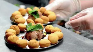  ?? PHOTOS: MEGAN GATTEY/FAIRFAX NZ ?? Above: Duck liver parfait with donut holes. Below left: Kyle Street puts the finishing touches on the ‘ugly’ carrots.