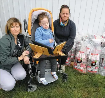  ?? PHOTO COLLABORAT­ION SPÉCIALE SIMON DESSUREAUL­T ?? Emma Hervieux est dans sa poussette avec ses tablettes, avec sa mère Johanne Gaudet et Mélissa-Jessy Lévesque, qui est assise sur les sacs de goupilles.