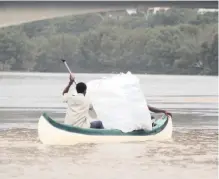  ??  ?? DURBANITES came out in their numbers this week to help clear the shoreline of plastic pollution washed down during a storm. Seen here, huge bags filled with plastic are ferried across the river mouth, ready for collection.