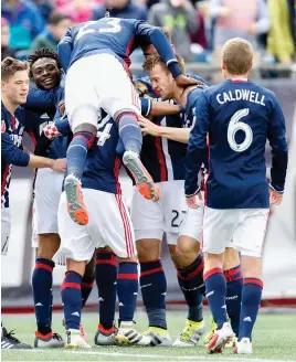  ?? USA TODAY SPORTS PHOTO ?? PILING ON: Revolution players surround forward Juan Agudelo (not pictured) after he scored a goal during the second half of yesterday’s 2-0 victory against Houston at Gillette Stadium.