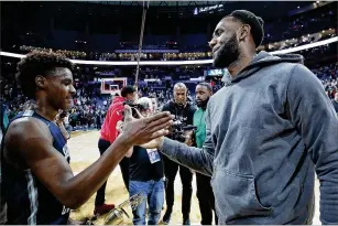  ?? JOE ROBBINS / GETTY IMAGES ?? LeBron “Bronny” James Jr. of Sierra Canyon High School in Los Angeles’ Chatsworth neighborho­od is greeted by his father, superstar LeBron James of the Los Angeles Lakers, following the Ohio Scholastic Play-By-Play Classic against St. Vincent-St. Mary High School, the elder James’ alma mater, last Saturday in Columbus, Ohio.