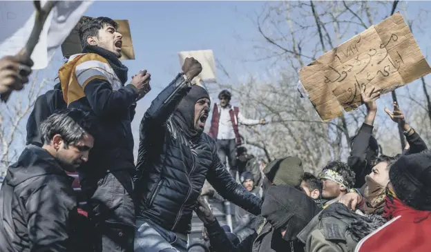  ?? PICTURE: AFP ?? 0 Migrants chant slogans as they demonstrat­e in the Turkey-greece border buffer zone, near Pazarkule crossing gate in Edirne, Turkey