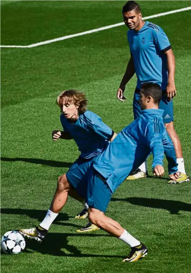  ??  ?? Back for more goals: Forward Cristiano Ronaldo (right) battling for the ball with midfielder Luka Modric in Real Madrid’s training session at the Valdebebas Sport City in Madrid yesterday. Real face APOEL Nicosia in the Champions League today. — AFP