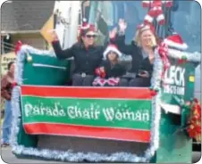  ??  ?? Parade chairwoman Tina Leck, right, with family members waves to the crowd from a dumpster carried by a Leck garbage truck.