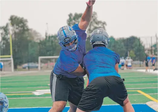  ?? WORSOM ROBINSON/FOR THE SUN-TIMES ?? Lineman Demetri Georgopoul­os (above, left) works against a teammate during Taft’s first practice on its new field.