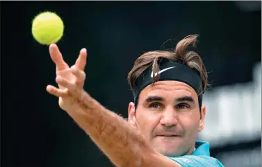  ?? MARIJAN MURAT / DPA VIA AP ?? Roger Federer serves to Milos Raonic during Sunday’s final of the ATP Mercedes Cup in Stuttgart, Germany. Federer won 6-4, 7-6 (3) and regained the world No 1 ranking.