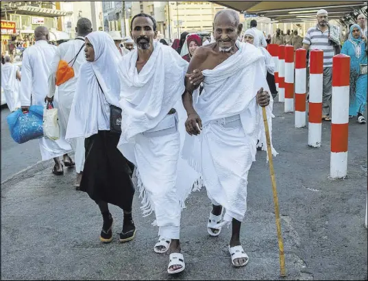  ?? Dar Yasin The Associated Press ?? Pilgrims walk Saturday toward the Grand Mosque in Mecca, Saudi Arabia, to offer prayers ahead of the annual hajj pilgrimage.