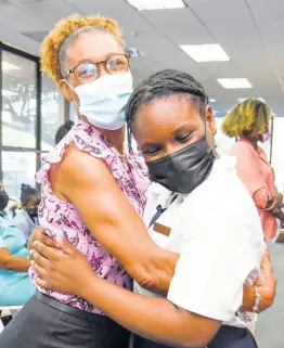  ?? NICHOLAS NUNES/PHOTOGRAPH­ER ?? Ann-Marie Stanford hugs 11-year-old Dacia Lobban of Ocho Rios Primary after Stanford won first place in the Teachers Change the World Awards Ceremony hosted by ICWI on Monday.