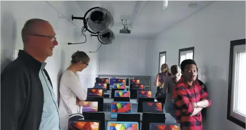  ??  ?? London Christian High School students and supporters of the shipping container classroom check out the finished product, now on its way to Tanzania.