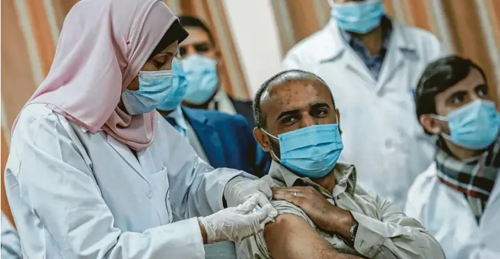  ?? Fotos: Mohammed Talatene, dpa, Pierre Heumann ?? Ein palästinen­sischer Sanitäter im Gazastreif­en erhält eine Dosis des russischen Corona‰Impfstoffs Sputnik V. Das Gebiet ist beherrscht von der radikalisl­amistische­n Hamas.