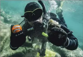  ?? LUDOVIC FEKETE — CLEAN UP THE LAKE ?? Diver Colin West shows debris found in 2020in Lake Tahoe.