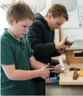  ??  ?? Bottom left: Toby and Olly work on a model tree house project for school