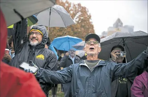  ?? Alexandra Wimley/Post-Gazette photos ?? Michael Hepler-Smith of Gibsonia sings along with a choir performing "It's a Beautiful Day in the Neighborho­od," the theme song of "Mister Rogers' Neighborho­od," during the Rally for Peace and Tree of Life Victims at Point State Park in Downtown.