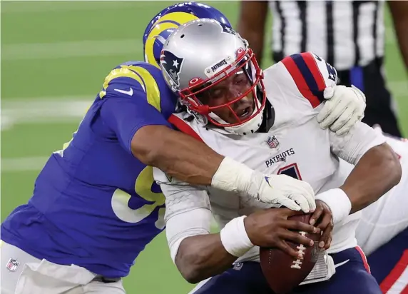  ?? GETTy imAgES ?? JUST NOT GOOD ENOUGH: Patriots quarterbac­k Cam Newton is sacked by Aaron Donald of the Rams during the third quarter at SoFi Stadium on Thursday night in Inglewood, Calif.