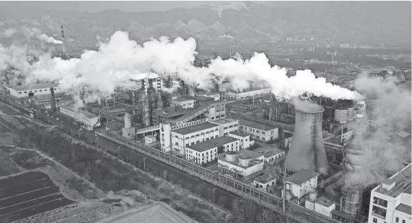  ?? SAM MCNEIL/AP FILE ?? Smoke and steam rise from a coal processing plant in Hejin in central China's Shanxi Province last November. The Internatio­nal Energy Agency, a policy advisory group to 30 member countries, projects that global carbon emissions are set to fall by 8%, or levels the world hasn't seen for a decade.