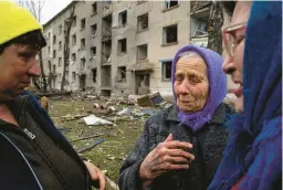 ?? EVGENIY MALOLETKA/AP ?? An evacuee, 79, says goodbye to her neighbors Tuesday after an airstrike in Lukiantsi, Ukraine.