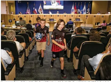  ?? JAY JANNER / AMERICAN-STATESMAN ?? Young soccer fans walk through the City Council Chambers while Austin City Council debates the MLS stadium deal at City Hall on Wednesday.