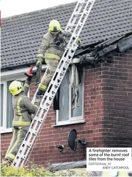  ?? ANDY CATCHPOOL ?? A firefighte­r removes some of the burnt roof tiles from the house 020720Acla­y_10