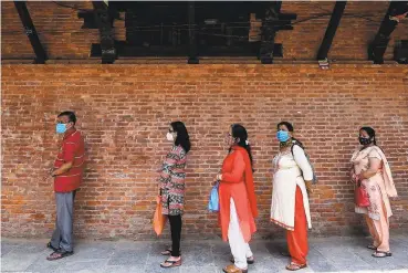  ?? Prakash Mathema / AFP via Getty Images ?? People line up in Kathmandu after Nepal resumed its stalled coronaviru­s vaccinatio­n campaign with 1 million doses given by China. The nation had made internatio­nal pleas for help due to a shortage of doses.