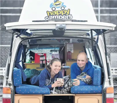  ?? PHOTOS: PETER MCINTOSH ?? Popular spot . . . German tourists Rahel (left) and Jan enjoy a hot drink at the Thomas Burns St freedom camping site in Dunedin yesterday morning. Below: Vehicles line the new camping site.