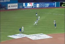  ?? FRED THORNHILL — THE ASSOCIATED PRESS ?? Royals players throw baseballs Monday next to tarps protecting the Rogers Centre field from water coming through a hole in the roof. The Blue Jays’ game against Kansas City was postponed over safety concerns.