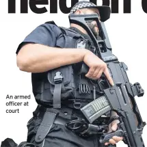  ??  ?? An armed officer at court